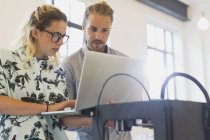 Designers with laptop at 3D printer in office — Stock Photo