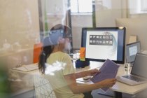 Женщина-дизайнер работает за компьютером в офисе — стоковое фото