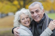 Porträt lächelnd, selbstbewusstes Senioren-Paar umarmt — Stockfoto
