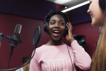 Teenage girl musicians recording music, singing in sound booth — Stock Photo