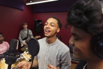 Teenage musicians recording music, singing in sound booth — Stock Photo