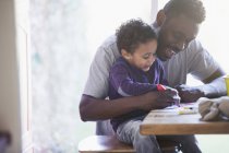 Happy father and toddler son coloring at table — Stock Photo