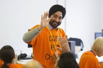Happy hackers high-fiving, coding for charity at hackathon — Stock Photo