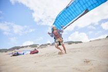 Male paraglider running with parachute on beach — Stock Photo