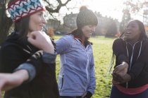 Жінки бігуни тягнуться в сонячному парку — стокове фото