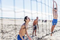 Чоловіки грають у пляжний волейбол на сонячному пляжі — стокове фото