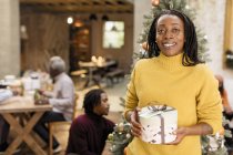 Portrait smiling, confident woman holding Christmas gift — Stock Photo