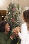 Enthusiastic mother giving Christmas gift to daughter — Stock Photo