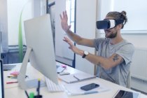 Männlicher Computerprogrammierer programmiert Virtual-Reality-Simulator-Brille am Computer im Büro — Stockfoto