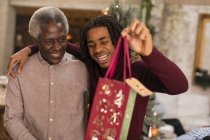 Grandson giving Christmas gift to grandfather — Stock Photo