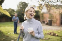 Portrait of blonde mature woman having coffee break in garden — Stock Photo