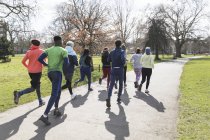 Grupo de corredores corriendo en el soleado parque - foto de stock