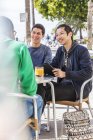 Мужские друзья в кафе на тротуаре — стоковое фото