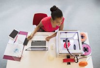 Жінка-дизайнер на ноутбуці дивиться 3D принтер — стокове фото