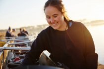 Smiling female rower preparing scull — Stock Photo