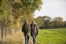 Mature caucasian couple walking together in autumn park — Stock Photo