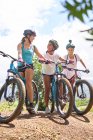 Women friends mountain biking on sunny trail — Stock Photo