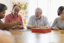 Amici anziani che giocano a giochi a tavolo nel centro della comunità — Foto stock