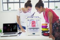 Diseñadoras viendo impresora 3D en la oficina - foto de stock