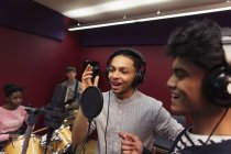 Teenage musicians recording music in sound booth — Stock Photo