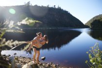 Romantic, carefree couple at sunny summer lake — Stock Photo