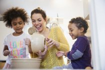 Mother and happy children baking in kitchen — Stock Photo