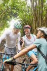 Чоловіки друзі гірські велосипеди, використовуючи смартфон у лісі — стокове фото
