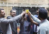 Друзья пьют пиво и коктейли на вечеринке в патио — стоковое фото