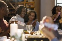 Mother and daughter using smart phone at Christmas dinner — Stock Photo