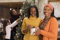 Portrait smiling women sisters holding Christmas gift — Stock Photo