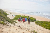 Параглідери, що перевозять парашутні рюкзаки на океанічному пляжі — стокове фото