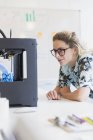 Жінка-дизайнер дивиться 3D-принтер в офісі — стокове фото
