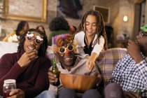 Verspielte Mehrgenerationenfamilie trägt Weihnachtsgläser, genießt Popcorn — Stockfoto