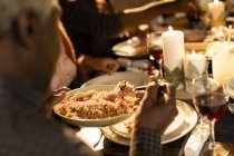 Family enjoying Christmas dinner, serving food — Stock Photo