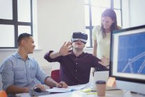 Programadores informáticos probando gafas de simulador de realidad virtual en la oficina - foto de stock