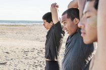 Мужчины, бегущие с протянутыми руками на солнечном пляже — стоковое фото