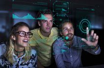 Diseñadores que ven datos en la pantalla del holograma futurista - foto de stock