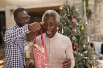 Внук удивляет дедушку рождественским подарком — стоковое фото