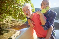 Ritratto giocoso padre e figlio al soleggiato lago estivo — Foto stock