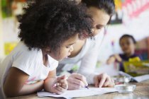 Mother and curious daughter coloring at home — Stock Photo
