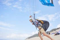 Чоловічий парашут біжить з парашутом на пляжі — стокове фото