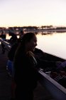Улыбающаяся женщина гребец на черепе на восходе солнца озера — стоковое фото