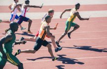 Relay runners racing on track — Stock Photo