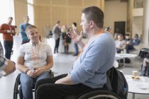 Ділові люди в інвалідних візках говорять на конференції — стокове фото