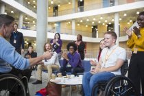 Kollegen klatschen für Redner im Rollstuhl bei Konferenz — Stockfoto
