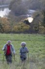 Active senior couple hiking up rural hillside — Stock Photo