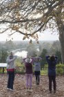 Active seniors practicing yoga in autumn park — Stock Photo