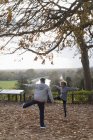 Exercício de casal sênior ativo, alongamento no parque de outono — Fotografia de Stock