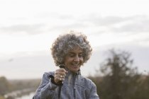 Улыбающаяся активная пожилая женщина в походе с шестом — стоковое фото