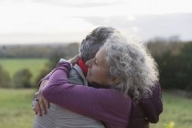 Affettuosa coppia anziana che si abbraccia sul campo — Foto stock